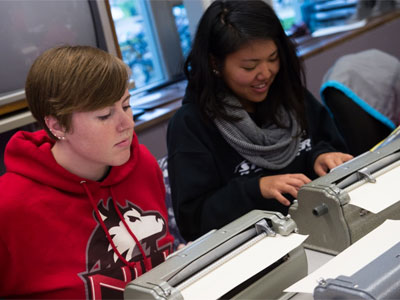 NIU students work with Braille typewriters.