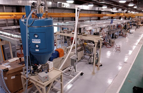 The plastic scintillator extrusion line, shown here, produces detector material for export to experiments around the world. Photo: Reidar Hahn