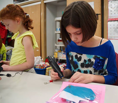 A student in one of the very first STEM Divas classes, held on campus at Northern Illinois University and facilitated by STEM Outreach, works with her Doodler 3D printer pen to create 3-dimensional jewelry.
