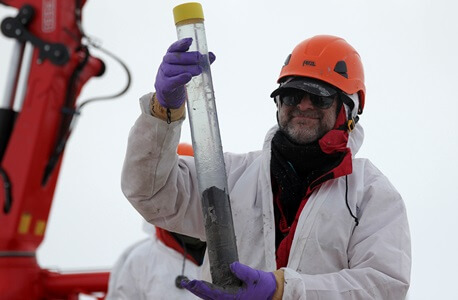 x-NIU Geology Professor Reed Scherer holds a sediment sample recovered from the grounding zone