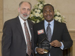 Anthony Roberts displays his award with President Baker