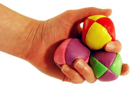 Photo of a hand holding three balls to juggle