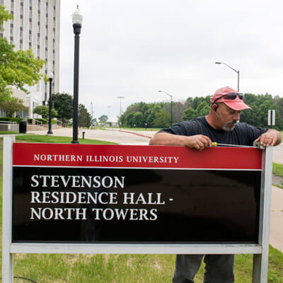 New campus signage is installed outside the North Towers of Stevenson Residence Hall.