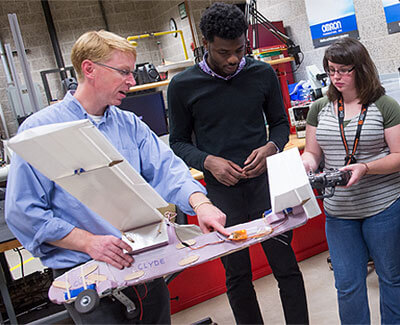 Brianno Coller (left) works with engineering students.