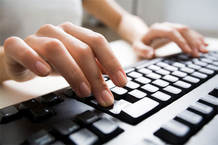 Photo of fingers typing on a computer keyboard