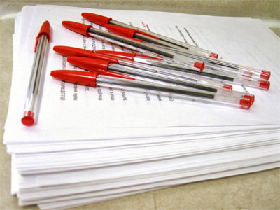 Photo of red pens on a stack of paper