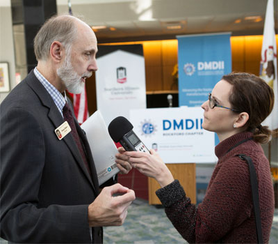 WNIJ reporter Jenna Dooley interviews NIU President Doug Baker at Monday’s DMDII announcement.