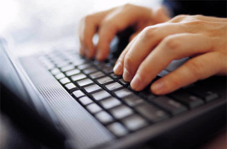 Photo of hands typing on a computer