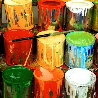 Photo of cans of paint and an artist’s brush