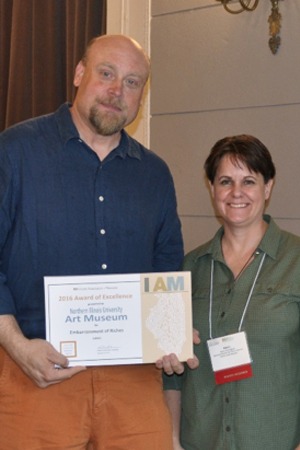 NIU A. rt Museum Assistant Director and Curator Peter Olson accepts the IAM Award of Excellence from Karen Everingham, IAM President and Interim Director for Visitor Services at the Illinois State Museum, at the organization’s Annual Conference  